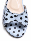 A close-up of a light blue leather shoe with black polka dots and a matching bow detail on the toe strap, set against a plain white background.